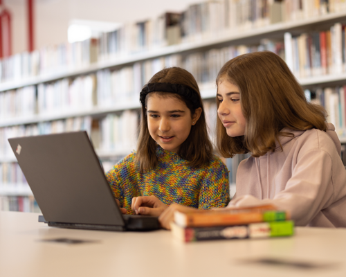Deux demoiselles qui font des recherches sur l'ordinateur